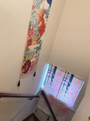 a surfboard hanging on a wall next to a staircase at B & K Nakanosakaue in Tokyo