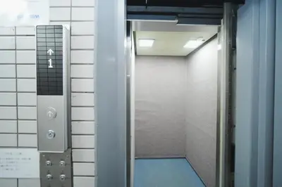 an elevator in a room with a door and a hallway at \u6771\u4eac\u30ea\u30ea\u30a2\u30eb\u30db\u30c6\u30eb501 in Tokyo