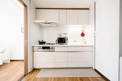 a kitchen with white cabinets and a microwave at \u590f\u7f8e\u30db\u30c6\u30eb in Tokyo