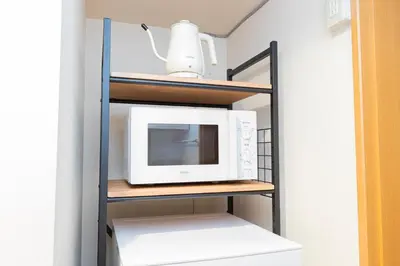 a microwave on a shelf in a kitchen at Asakusa and Ueno Area, 2 Minutes to Iriya Station, Very Convenient in Tokyo