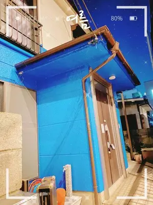 a blue building with a door on the side of it at \u5c0f\u5ca9\u6c11\u6cca\u5bbf in Tokyo