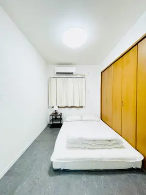 a bedroom with a large bed with a wooden headboard at Alo BnB 10 - Near AKIHABARA, UENO, ASAKUSA, TOKYO SKY TREE - Self check-in in Tokyo