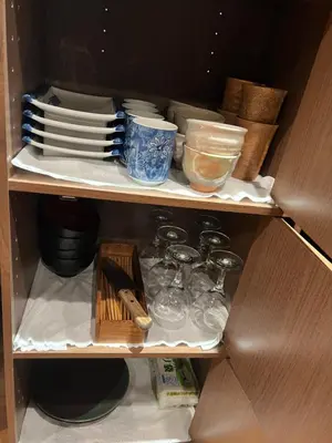 a cabinet filled with plates and bowls and utensils at \u6cca\u9732Hakuro 1\u968e in Tokyo