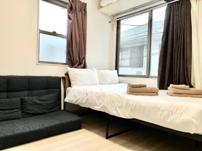a bed and a couch in a room with windows at \u30b0\u30ec\u30a4\u30b7\u30e3\u30b9\u6771\u65b0\u5bbf \u6771\u65b0\u5bbf\u99c5\u5f92\u6b693\u5206 \u65b0\u5927\u4e45\u4fdd\u99c5\u5f92\u6b697\u5206 \u65b0\u5bbf\u99c5\u5f92\u6b6915\u5206 \u6b4c\u821e\u4f0e\u753a\u3059\u3050\u8fd1\u304f \u7f8e\u5473\u3057\u3044\u97d3\u56fd\u6599\u7406\u5c4b\u591a\u6570\u3042\u308a\u307e\u3059 in Tokyo