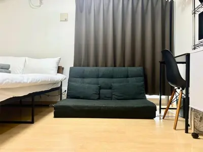 a bedroom with a green ottoman in front of a bed at \u30b0\u30ec\u30a4\u30b7\u30e3\u30b9\u6771\u65b0\u5bbf \u6771\u65b0\u5bbf\u99c5\u5f92\u6b693\u5206 \u65b0\u5927\u4e45\u4fdd\u99c5\u5f92\u6b697\u5206 \u65b0\u5bbf\u99c5\u5f92\u6b6915\u5206 \u6b4c\u821e\u4f0e\u753a\u3059\u3050\u8fd1\u304f \u7f8e\u5473\u3057\u3044\u97d3\u56fd\u6599\u7406\u5c4b\u591a\u6570\u3042\u308a\u307e\u3059 in Tokyo