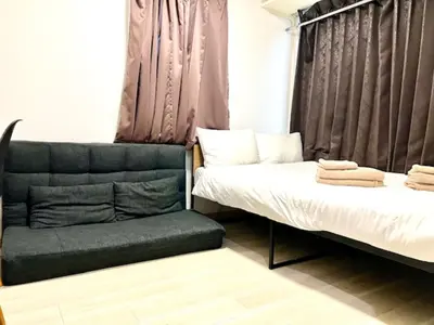 two beds and a chair in a room at \u30b0\u30ec\u30a4\u30b7\u30e3\u30b9\u6771\u65b0\u5bbf \u6771\u65b0\u5bbf\u99c5\u5f92\u6b693\u5206 \u65b0\u5927\u4e45\u4fdd\u99c5\u5f92\u6b697\u5206 \u65b0\u5bbf\u99c5\u5f92\u6b6915\u5206 \u6b4c\u821e\u4f0e\u753a\u3059\u3050\u8fd1\u304f \u7f8e\u5473\u3057\u3044\u97d3\u56fd\u6599\u7406\u5c4b\u591a\u6570\u3042\u308a\u307e\u3059 in Tokyo