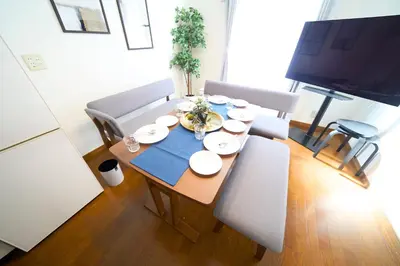 a dining room table with chairs and a television at FINOA Residential Suite Kita-Ikebukuro in Tokyo