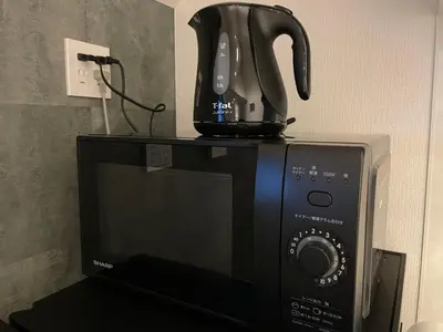 a coffee pot on top of a microwave at COTO Premium Shibuya A in Tokyo