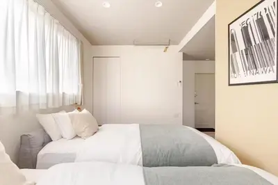 a bedroom with two beds and a window at Home Suite Home Ikejiri - Shibuya 1 Stop! Sleek Confort with Washer and Dryer in Tokyo