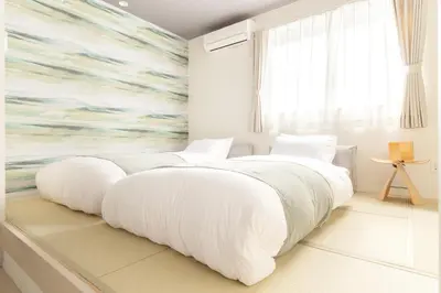 a white bedroom with two beds and a large window at Home Suite Home Ikejiri - Shibuya 1 Stop! Sleek Confort with Washer and Dryer in Tokyo