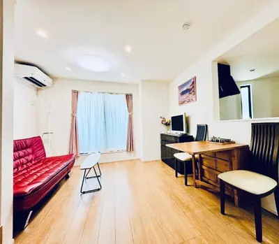 a living room with a red couch and a desk at \u4e1c\u4eac\u6c60\u888b\u57ce\u5e02\u4f4f\u5bbf-Ikebukuro Urban Stay in Tokyo