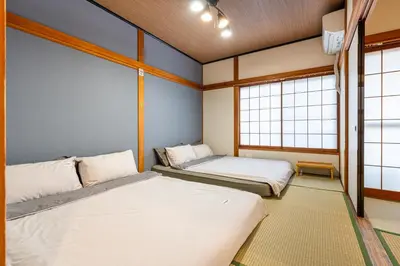 two beds in a room with two windows at \u6674\u7a7a\u6c11\u5bbf Sora House \u6674\u7a7a\u5854\u5f92\u6b65\u5708 \u6574\u680b\u51fa\u79df in Tokyo