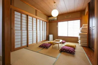 a room with pillows and a table and some windows at \u677e\u304c\u4e181\u4e01\u76ee in Tokyo