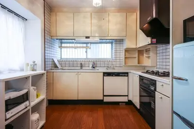 a kitchen with white cabinets and a wooden floor at \u677e\u304c\u4e181\u4e01\u76ee in Tokyo