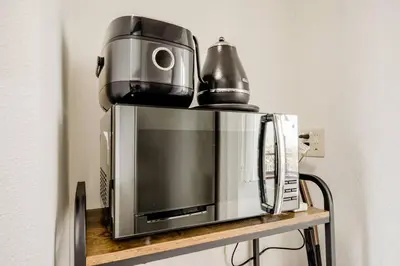a coffeemaker sitting on top of a microwave at \u4e09\u5bbf1\u4e01\u76ee in Tokyo