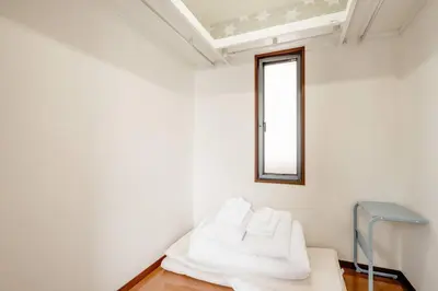 a white room with a bed and a window at \u4e09\u5bbf1\u4e01\u76ee in Tokyo