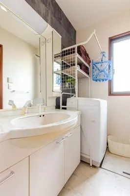 a white bathroom with a sink and a refrigerator at \u4e09\u5bbf1\u4e01\u76ee in Tokyo