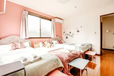three beds in a room with pink walls at \u4e09\u5bbf1\u4e01\u76ee in Tokyo