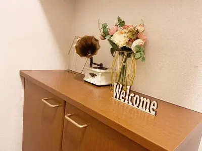 a vase of flowers on a counter with a welcome sign at \u4e09\u5bbf1\u4e01\u76ee in Tokyo