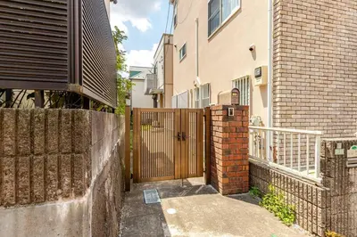 an entrance to a house with a gate and a fence at \u4e09\u5bbf1\u4e01\u76ee in Tokyo