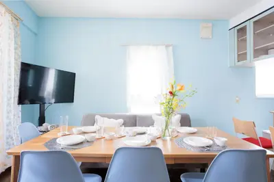 a dining room with a table with chairs and a television at MIKO'S HOUSE SETAGAYA, Peaceful Tokyo Home Near Shinjuku, Experience Authentic Local Living, Lucky Cat Temple, Super Market 東京の家 新宿10分 隠れ家カフェ 豪徳寺 in Tokyo