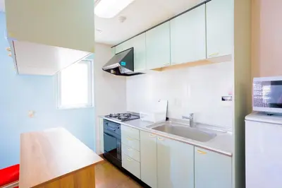 a kitchen with white cabinets and a sink at MIKO'S HOUSE SETAGAYA, Peaceful Tokyo Home Near Shinjuku, Experience Authentic Local Living, Lucky Cat Temple, Super Market 東京の家 新宿10分 隠れ家カフェ 豪徳寺 in Tokyo
