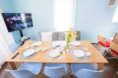 a dining room table with chairs and a television at MIKO'S HOUSE SETAGAYA, Peaceful Tokyo Home Near Shinjuku, Experience Authentic Local Living, Lucky Cat Temple, Super Market 東京の家 新宿10分 隠れ家カフェ 豪徳寺 in Tokyo