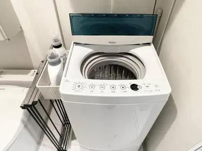 a washer and dryer in a corner of a room at GraceCourt Oyama Near Ikebukuro Studio Apartment in Tokyo