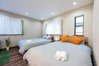 two beds in a room with two windows at YJ-HOTEL kamiikebukuro 2F \u5317\u6c60\u888b5\u5206\u949f \u65b0\u88c5\u4e0a\u7ebf 59\u5e73\u65b9 in Tokyo