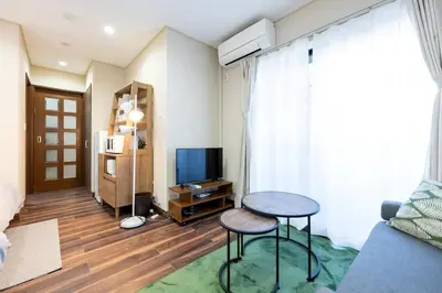 a living room with a table and a television at YJ-HOTEL kamiikebukuro 2F \u5317\u6c60\u888b5\u5206\u949f \u65b0\u88c5\u4e0a\u7ebf 59\u5e73\u65b9 in Tokyo