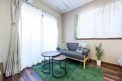 a living room with a couch and a table at YJ-HOTEL kamiikebukuro 2F \u5317\u6c60\u888b5\u5206\u949f \u65b0\u88c5\u4e0a\u7ebf 59\u5e73\u65b9 in Tokyo