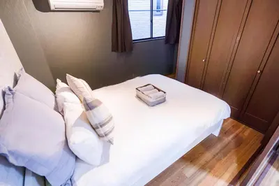 a bedroom with a white bed with a box on it at Charming Guesthouse in the Heart of Okubo \u4e36Steps to Metro and Convenient Travel! EoW4 in Tokyo