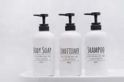 a group of four white shampoo bottles on a counter at Charming Guesthouse in the Heart of Okubo \u4e36Steps to Metro and Convenient Travel! EoW4 in Tokyo