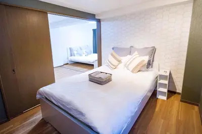 a bedroom with a large white bed with a box on it at Charming Guesthouse in the Heart of Okubo \u4e36Steps to Metro and Convenient Travel! EoW4 in Tokyo