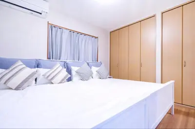 a bedroom with a large white bed with blue accents at Charming Guesthouse in the Heart of Okubo \u4e36Steps to Metro and Convenient Travel! EoW4 in Tokyo