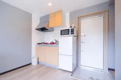 a kitchen with a white refrigerator and a microwave at CG Charming Guesthouse in the Heart of Okubo \u4e36Steps to Metro and Convenient Travel! SoS4 in Tokyo