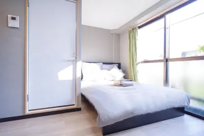 a bedroom with a bed and a large window at CG Charming Guesthouse in the Heart of Okubo \u4e36Steps to Metro and Convenient Travel! SoS4 in Tokyo