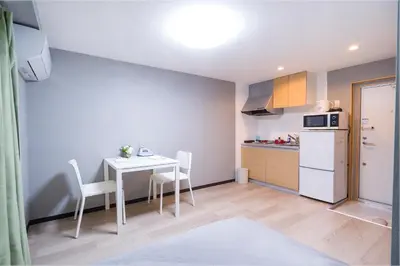 a small kitchen with a white table and chairs at CG Charming Guesthouse in the Heart of Okubo \u4e36Steps to Metro and Convenient Travel! SoS4 in Tokyo