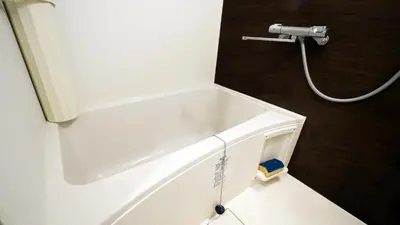 a white bath tub in a bathroom with a hose at Charming Guesthouse in the Heart of Okubo \u4e36Steps to Metro and Convenient Travel! YoS4 in Tokyo