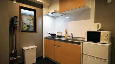 a small kitchen with a sink and a microwave at Charming Guesthouse in the Heart of Okubo \u4e36Steps to Metro and Convenient Travel! YoS4 in Tokyo