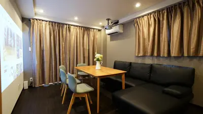 a living room with a table and a couch at Charming Guesthouse in the Heart of Okubo \u4e36Steps to Metro and Convenient Travel! YoS4 in Tokyo