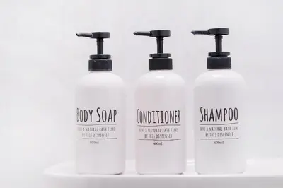 a group of four white shampoo bottles on a shelf at CG Charming Guesthouse in the Heart of Okubo \u4e36Steps to Metro and Convenient Travel! YoE4 in Tokyo