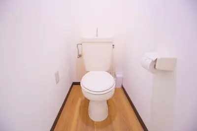 a white toilet in a bathroom with a wooden floor at Charming Guesthouse in the Heart of Okubo \u4e36Steps to Metro and Convenient Travel! EoS11 in Tokyo