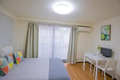a bedroom with a bed and a desk with a computer at Charming Guesthouse in the Heart of Okubo \u4e36Steps to Metro and Convenient Travel! EoS11 in Tokyo