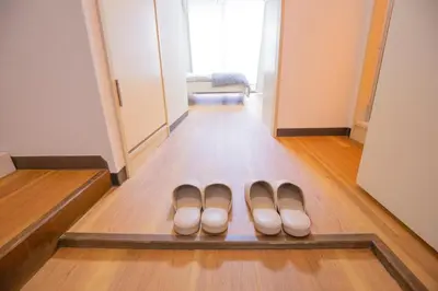 two pairs of shoes sitting on a floor in a hallway at Charming Guesthouse in the Heart of Okubo \u4e36Steps to Metro and Convenient Travel! EoS11 in Tokyo