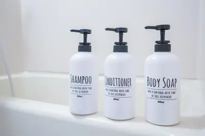a group of four white bottles sitting on a bathroom counter at Charming Guesthouse in the Heart of Okubo \u4e36Steps to Metro and Convenient Travel! EoS11 in Tokyo