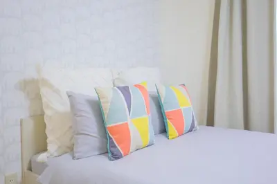 a bed with four pillows on top of it at Charming Guesthouse in the Heart of Okubo \u4e36Steps to Metro and Convenient Travel! EoS11 in Tokyo