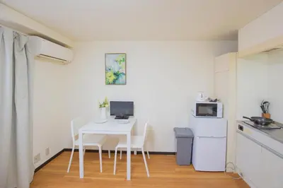 a small kitchen with a white table and chairs at Charming Guesthouse in the Heart of Okubo \u4e36Steps to Metro and Convenient Travel! EoS11 in Tokyo