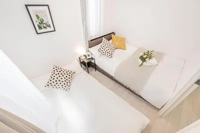 two beds in a small room with white walls at \u65b0\u5bbf16 Shinjuku16 in Tokyo