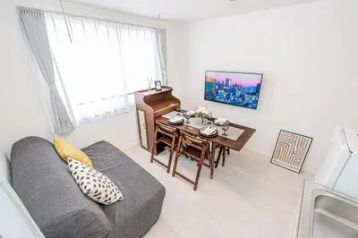 a living room with a couch and a table and a piano at \u65b0\u5bbf16 Shinjuku16 in Tokyo